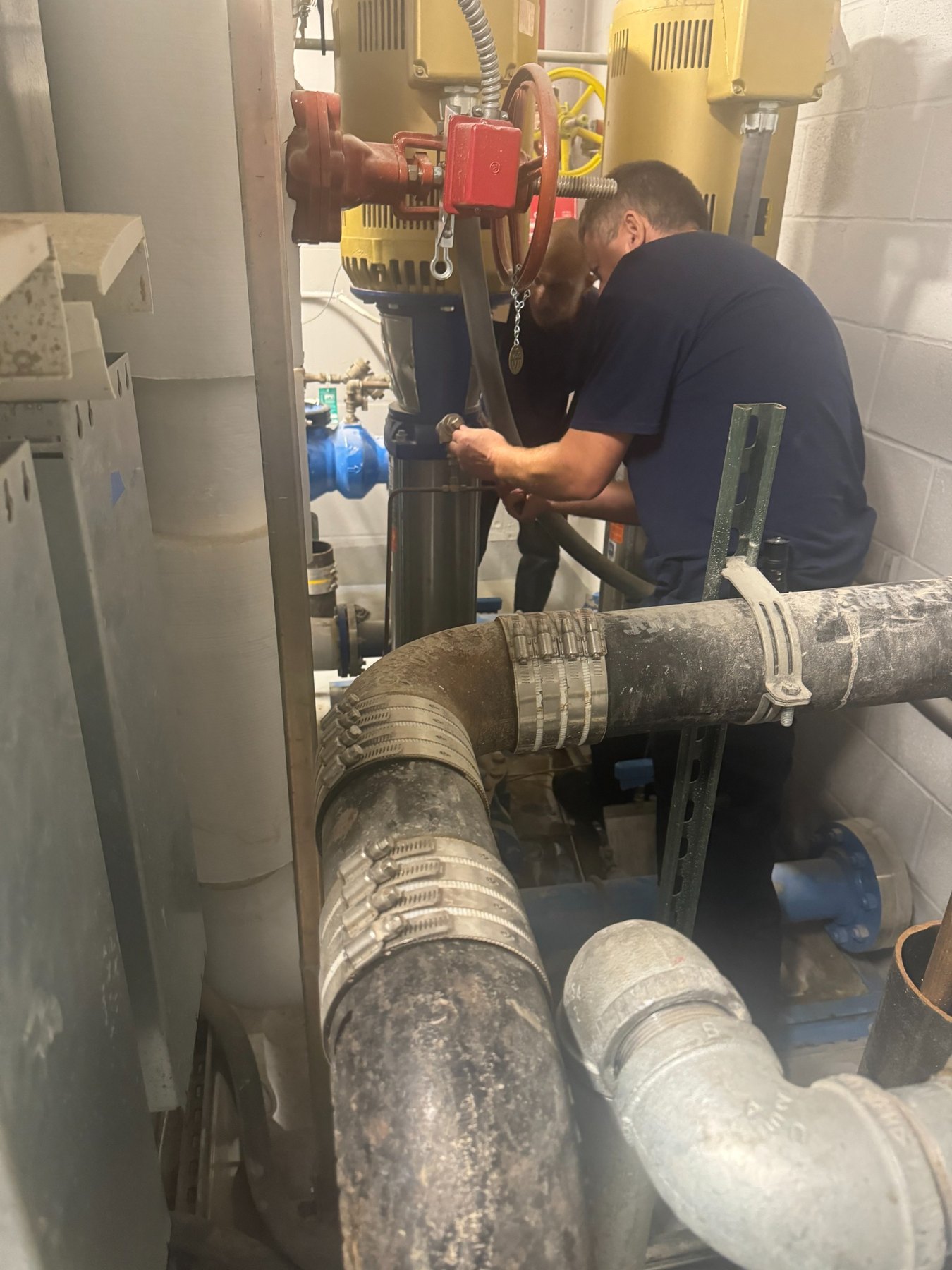Technician servicing building pump equipment